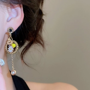 Detail of fan-shaped tassel earring with white daisy flower and crystal pendant