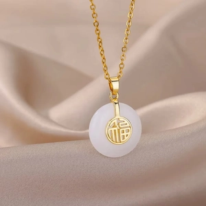 Macro shot of white lucky buckle pendant with gold Fu character on brown silk