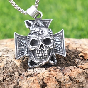 Vintage stainless steel gothic skull and cross pendant necklace on rustic tree bark