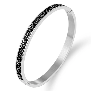 Polished silver stainless steel bangle featuring white daisy patterns on black enamel background