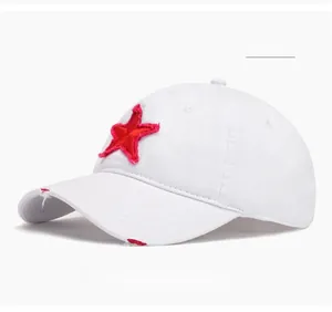 Close-up of the red star patch and distressed torn details on the white baseball cap