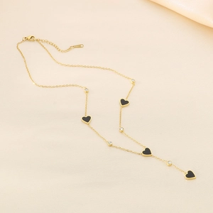 Elegant gold Y-shaped necklace featuring black heart pendants and sparkling zircon stones