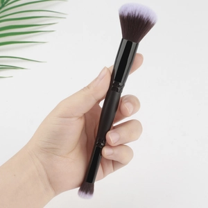 Gros plan du pinceau de maquillage double embout avec poils dégradés violets