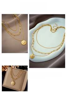 Detailed view of layered gold necklace featuring sunburst pendant and faux pearl accents