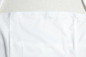 Gros plan sur le tissu en maille blanche et les coutures soignées d'une robe trapèze dos nu