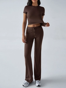 Detail view of women's dark brown short-sleeve top and high-waist drawstring flare pants