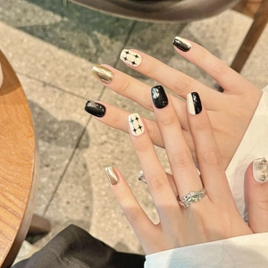 Handmade black and white press-on nails with star patterns and metallic mirror finish