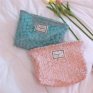 Detailed close-up of daisy lace embroidery on sky blue and pink floral cosmetic pouches