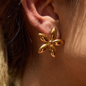 Elegant 18K gold plated stainless steel flower stud earrings worn by a model