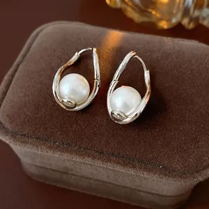 French vintage twisted gold pearl drop earrings on dark velvet jewelry box