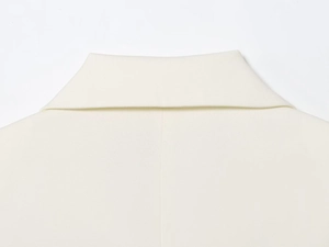 Detail shot of ivory double-breasted blazer lapel showing high-quality twill fabric texture