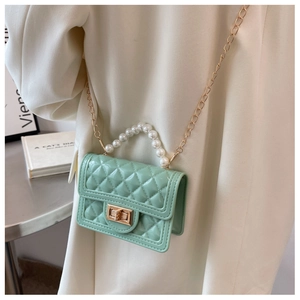 Detail of mint green quilted silicone mini bag with pearl handle and gold chain