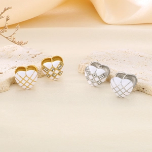 Close-up of heart-shaped checkerboard earrings with sparkling rhinestones and enamel finish