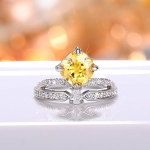 Macro-opname van zilveren kroonring met gele kussengeslepen steen en micro-pave zirkoon