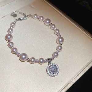 Detail of rose pearl bracelet with zircon pendant in luxury beige jewelry box