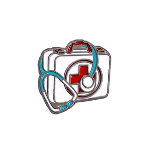 Broche en émail médical avec stéthoscope et trousse de secours sur fond blanc neutre