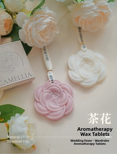 Dettaglio dei tavolette di cera profumata alla camelia con nastri di seta e scatola regalo