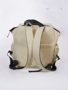Vue détaillée des bretelles ergonomiques et de la poche magnétique cachée du sac à dos beige