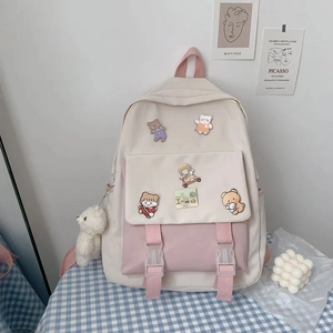 Detail of cream white and pink canvas school backpack with cute bear pendant