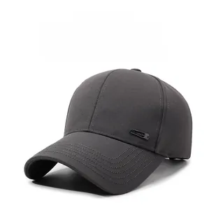 Detail view of a dark grey baseball cap showing diagonal twill and metal brand logo