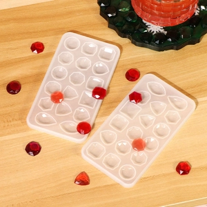 Stampi in silicone per gioielli con varie forme geometriche su fondo in legno