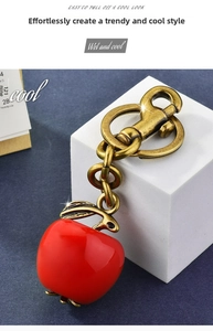 Detailed close-up of glossy red apple keychain with premium vintage brass finish lobster clasp