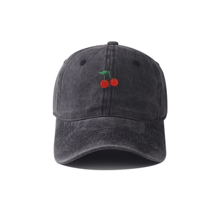 Close-up of embroidered cherry logo on vintage washed grey cotton baseball cap
