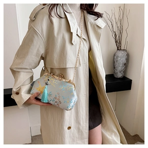Elegant embroidered evening clutch bag featuring blue tassel and gold chain strap