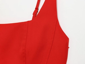 Détail macro de la robe rouge avec fines bretelles réglables et coutures de précision