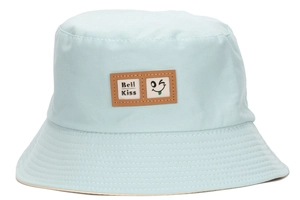 Detail view of sky blue bucket hat featuring brown Beil Kiss wink face patch and cotton twill