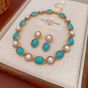 Vintage jewelry set featuring pearl and turquoise necklace with matching stud earrings
