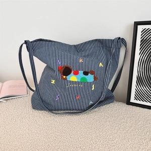Detail of blue striped canvas bag featuring cute puppy embroidery and SUZAKKA logo