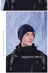 Detail of blue knitted beanie with geometric texture in snowy outdoor winter scenery