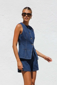 Détail d'un ensemble gilet sans manches et short en denim bleu foncé de haute qualité