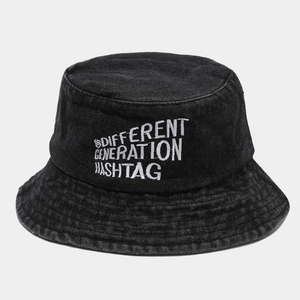 Détail d'un chapeau bob en denim noir avec broderie blanche et coutures renforcées