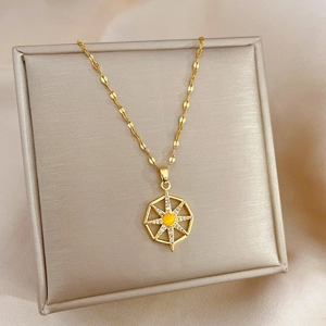 Macro shot of titanium steel starburst pendant with yellow stone on a jewelry box