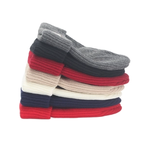 Multi-colored stack of warm ribbed knit beanies in classic winter styles and colors