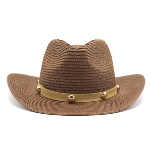Détail d'un chapeau de cowboy tressé marron montrant la paille et le bandeau riveté