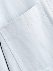 Macro view of double-stitched pocket detail and twill fabric texture on the casual shirt