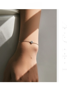 Close-up of sparkling s925 sterling silver four-leaf clover bracelet on woman wrist