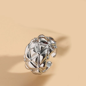 Detail of silver geometric quilted pattern on adjustable open ring with metallic finish