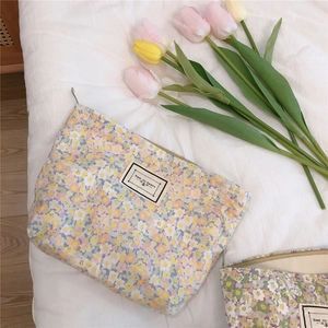 Detail showing floral canvas makeup bag with zipper closure and party label embroidery