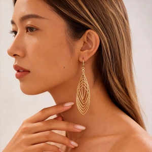 Elegant gold hollow teardrop earrings with zircon accents on a female model
