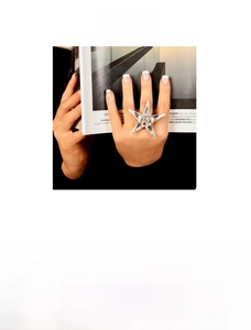 Detailed close-up of a large star-shaped rhinestone ring with gold and silver finishes