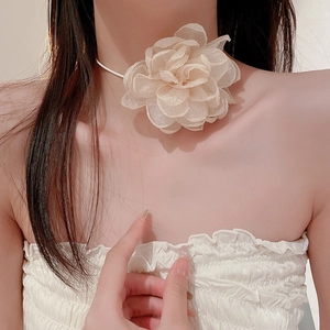 Close-up of beige fabric floral choker necklace with tulle petals on model neck
