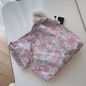 Detailed macro view of pink floral cotton shoulder bag with internal brand label