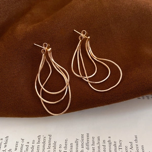 Vue détaillée de boucles d'oreilles pendantes dorées à plusieurs niveaux et chaînes