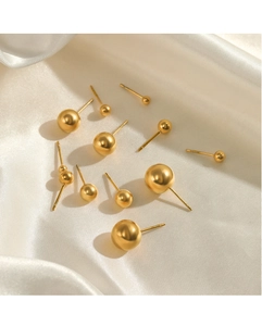 Macro detail of various sizes of polished gold stainless steel ball stud earrings