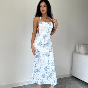 Detail of white floral halter dress with blue print and backless slit design