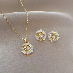 Elegant gold titanium steel jewelry set with pearls and leaf patterns on silk